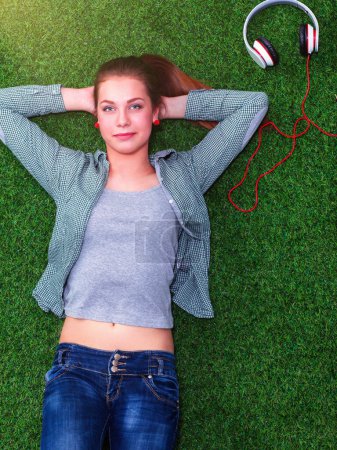 Téléchargez les photos : Femme détendue allongée sur l'herbe avec les mains sur la tête
. - en image libre de droit