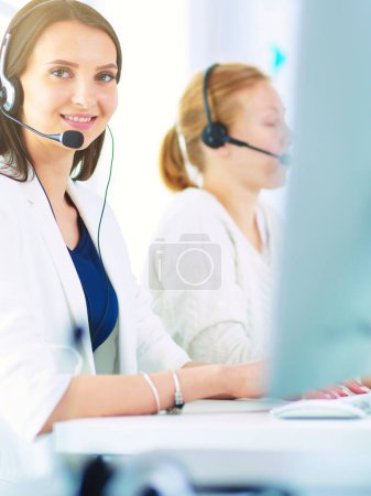 Téléchargez les photos : Femme d'affaires souriante ou opérateur de ligne d'assistance avec casque et ordinateur au bureau. - en image libre de droit