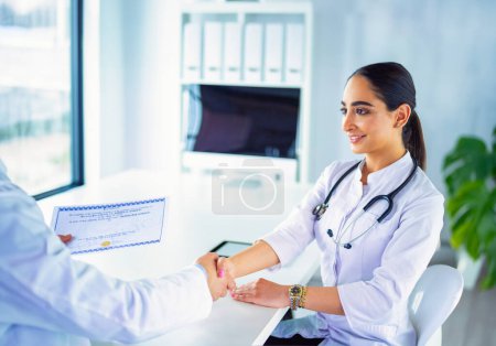 Téléchargez les photos : Le médecin serre la main d'un patient isolé sur fond blanc. - en image libre de droit