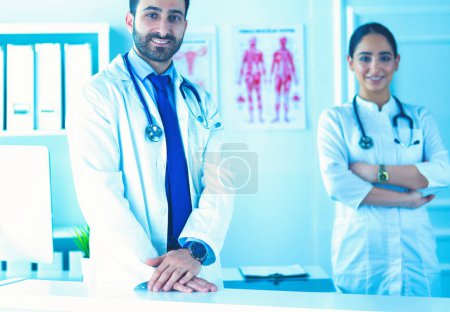 Photo for Attractive male doctor in front of medical group. - Royalty Free Image