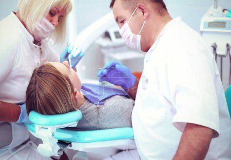 Téléchargez les photos : Le dentiste et son assistant effectuent un examen approfondi. - en image libre de droit