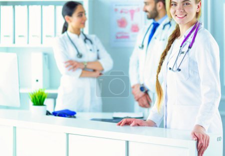 Photo for Attractive female doctor in front of medical group. - Royalty Free Image