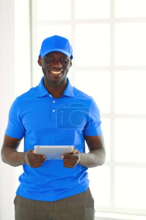 Photo for Portrait of an handsome happy deliverer with folder. - Royalty Free Image
