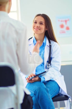 Photo for Doctor and patient discussing something while sitting at the table . Medicine and health care concept. - Royalty Free Image
