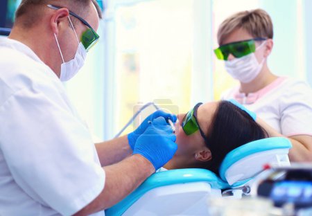Foto de Retrato de un dentista que trata los dientes de una paciente joven. - Imagen libre de derechos