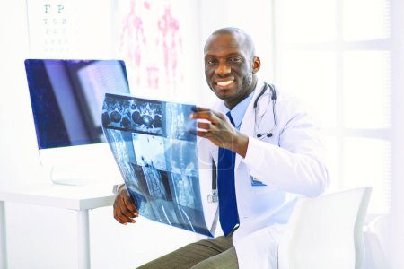 Téléchargez les photos : Portrait jeune médecin africain tenant des patients radiographie. - en image libre de droit
