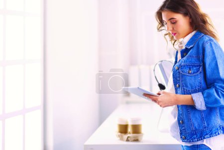 Photo for Smiling woman drinking coffee and using tablet in the cafe - Royalty Free Image