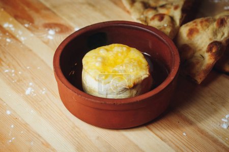 Eine Schüssel mit köstlichem Käse elegant auf einem rustikalen Holztisch platziert, bereit zum Servieren und Genießen.