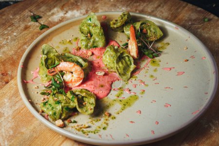 A plate adorned with juicy shrimp drenched in a vibrant green sauce, creating an enticing and flavorful culinary masterpiece.