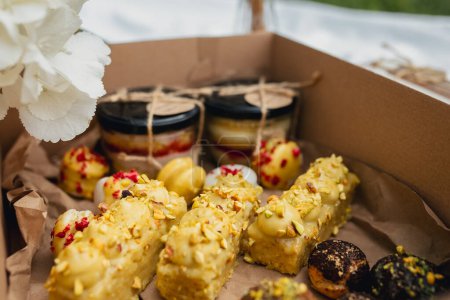Téléchargez les photos : Une somptueuse boîte débordant de desserts délicieux et de fleurs vibrantes, créant un festin pour les sens. - en image libre de droit