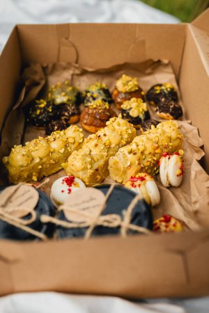 Una caja llena de una variedad de galletas y pasteles extendidos sobre la exuberante hierba verde.