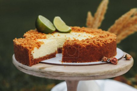 Una rebanada decadente de pastel de queso de lima descansando en un plato blanco prístino, mostrando un equilibrio perfecto de textura cremosa y sabor picante.