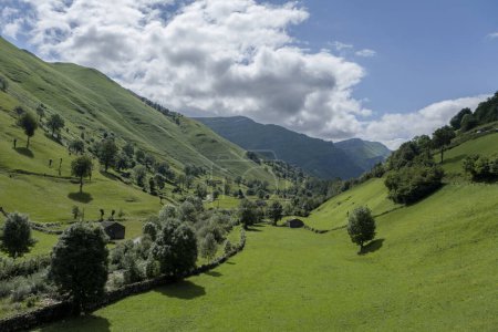 Foto de Prados y cabañas de piedra rústica en hermoso valle verde, Valles Pasiegos, Cantabria, España - Imagen libre de derechos