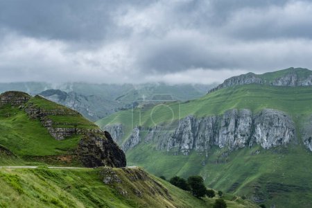 Paisaje montañoso áspero con pendientes verdes y empinadas de piedra caliza en Valles Pasiegos, Cantabria, España