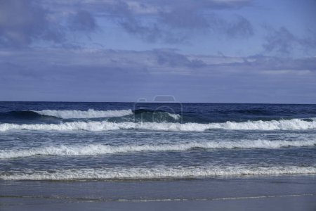 Foto de Ocean waves crashing on a wild sandy beach in the cantabrian coast, Spain - Imagen libre de derechos