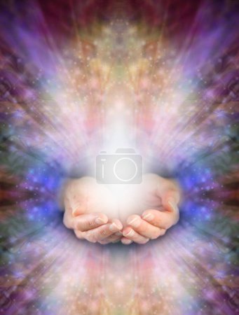 Photo for Offering you beautiful high resonance healing energy - female cupped hands with white light against radiating multicoloured angelic energy field and space for copy - Royalty Free Image