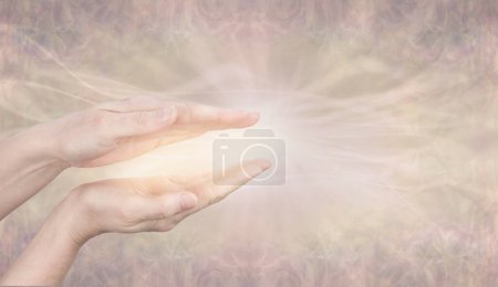 Einstimmung auf die Heilungsenergie der Göttlichen Intelligenz - Weibliche parallele Hände mit wunderschöner goldener glühender Energie vor einem fahlen, wispy fließenden goldenen Lichthintergrund mit Kopierraum 