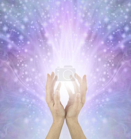 Téléchargez les photos : Il y a assez d "énergie curative pour tout le monde - Femme Reiki Master Healer avec les mains coupées envoyant de grandes quantités de lumière blanche sur un beau fond de champ d" énergie bleu rose et un espace de copie - en image libre de droit