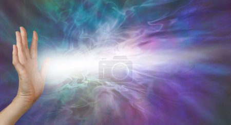 Photo for Beaming gentle pranic healing energy from palm chakra - female open hand with beam of white light coming from palm against an ethereal wispy energy background and space for copy - Royalty Free Image