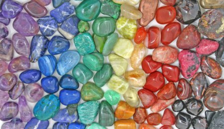Photo for Chakra Crystal Healing Background - Rows of tumbled polished healing crystal laid out in chakra colours purple, indigo, turquoise blue, green, yellow, orange, red ideal for crystal healing theme - Royalty Free Image