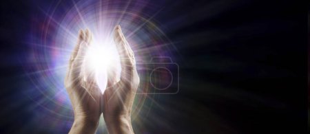 Téléchargez les photos : Envoi d'un modèle de concept de guérison quantique - Maître guérisseur Reiki mâle avec des mains parallèles atteignant la lumière de l'orbe d'étoile blanche contre un champ d'énergie vortex multicolore avec espace de copie pour message spirituel - en image libre de droit