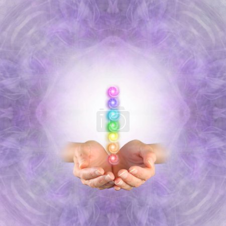 Foto de Maestro Reiki ofreciendo los siete chakras - cuadrado de fondo etéreo simétrico púrpura con las manos ahuecadas emergiendo y una pila de siete chakras vórtice flotando por encima - Imagen libre de derechos