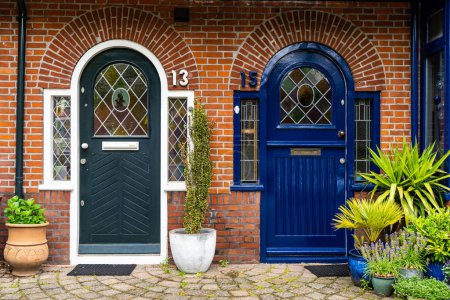 Foto de Vista de las hermosas puertas delanteras de dos casas adosadas holandesas vecinas en una calle holandesa Amsterdam. - Imagen libre de derechos