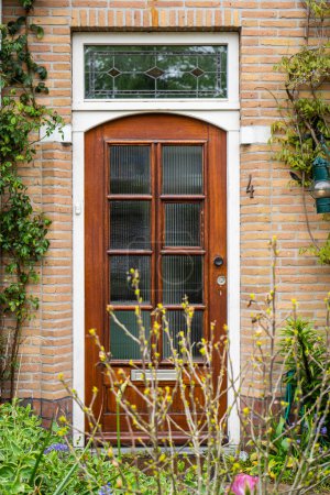 Photo for Facade of typical Dutch door house with brick walls, steps, front door windows. Doors on the street, Netherlands - Royalty Free Image