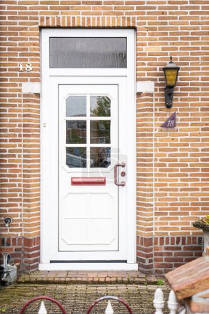 Foto de Fachada de la típica casa de la puerta holandesa con paredes de ladrillo, escaleras, ventanas de la puerta principal. Puertas en la calle, Países Bajos - Imagen libre de derechos