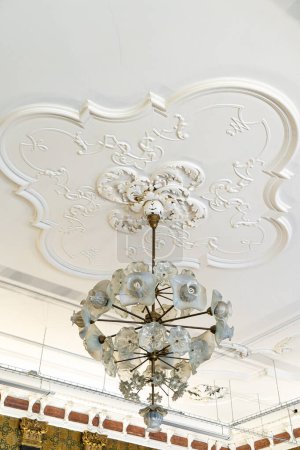 Round antique vintage decorative clay stucco relief molding with floral ornaments white ceiling in abstract classical style interior