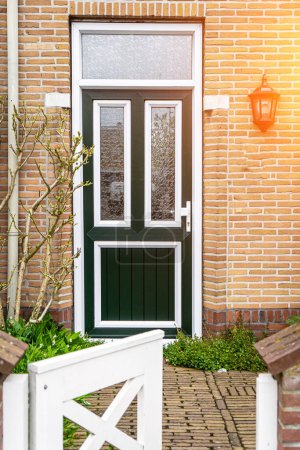 Photo for Facade of typical Dutch door house with brick walls, steps, front door windows. Doors on the street, Netherlands - Royalty Free Image
