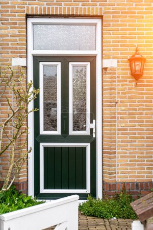 Fassade eines typisch holländischen Türhauses mit Ziegelwänden, Stufen, Haustürfenstern. Türen auf der Straße, Niederlande