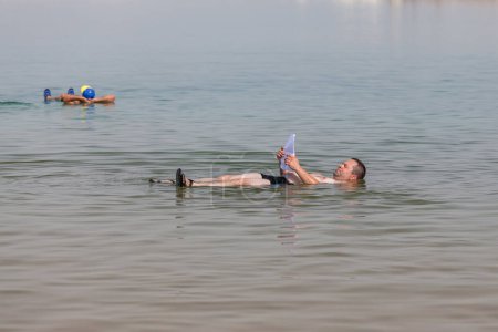 Téléchargez les photos : EIN BOKEK, ISRAEL - CIRCA MAI 2018 : Personnes flottant dans la mer Morte vers mai 2018 à Ein Bokek. - en image libre de droit