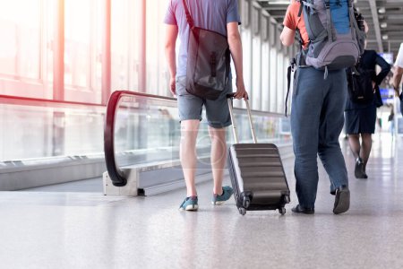 Unbekannte gehen mit Koffer in Flughafenterminal