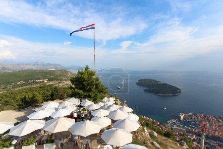 Photo for Experience enchanting Dubrovnik, where majestic cityscapes meet tranquil seasides and picturesque mountain hills. The proud Croatian flag waves gracefully, offering a glimpse into the iconic Game of Thrones location. Experience the allure of Dubrovni - Royalty Free Image