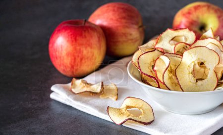 Téléchargez les photos : Bol de chips séchées aux pommes biologiques. Concept de collations santé - en image libre de droit