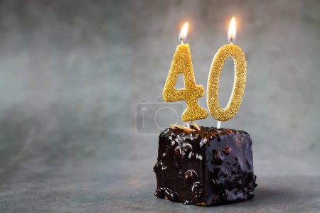 Birthday chocolate cake with number forty burning candles on dark background with copy space for your greetings