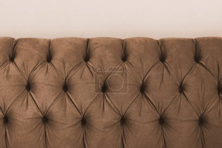 Téléchargez les photos : Tête de lit capitone textile capitone en velours marron de style Chesterfiels canapé, gros plan - en image libre de droit