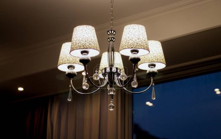 Hermosa lámpara de araña de estilo clásico colgando en el techo de la habitación del hotel