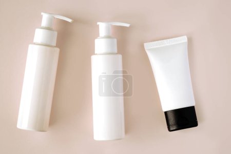 Téléchargez les photos : Bouteilles blanches et tube de produits cosmétiques avec maquette de marque sur fond de couleur pastel. Soin de la peau et concept beauté - en image libre de droit