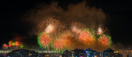 NITEROI, RIO DE JANEIRO, BRASIL 01 / 01 / 2023: Foto nocturna de la llegada del Año Nuevo (Reveillon) con fuegos artificiales en el cielo de una ciudad brasileña. Las ciudades organizan eventos públicos, donde tienen lugar conciertos y el ápice es la exhibición de fuegos artificiales.