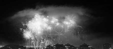 Téléchargez les photos : NITEROI, RIO DE JANEIRO, BRAZIL  01/01/2023: Night photo of the arrival of the New Year (Reveillon) in black and white with fireworks in the sky of a Brazilian city - en image libre de droit