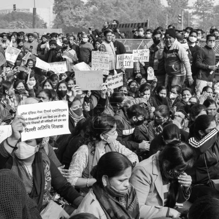 Téléchargez les photos : New Delhi, Inde 25 décembre 2021 - Delhi enseignants invités contractuels avec des affiches, des drapeaux et des graffitis protestant contre le gouvernement AAP de Delhi pour avoir élaboré une politique, Delhi enseignants invités protestant - en image libre de droit