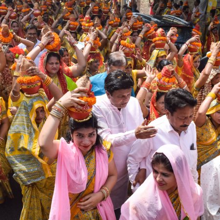 Téléchargez les photos : New Delhi, Inde Avril 03 2022 - Les femmes avec Kalash sur la tête pendant Jagannath Temple Mangal Kalash Yatra, dévots hindous indiens portent des pots en terre contenant de l'eau sacrée avec une noix de coco sur le dessus - en image libre de droit