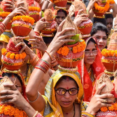 Photo for New Delhi, India April 03 2022 - Women with Kalash on head during Jagannath Temple Mangal Kalash Yatra, Indian Hindu devotees carry earthen pots containing sacred water with a coconut on top - Royalty Free Image