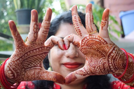 Photo for Beautiful woman dressed up as Indian tradition with henna mehndi design on her both hands to celebrate big festival of Karwa Chauth, Karwa Chauth celebrations by Indian woman for her husband - Royalty Free Image