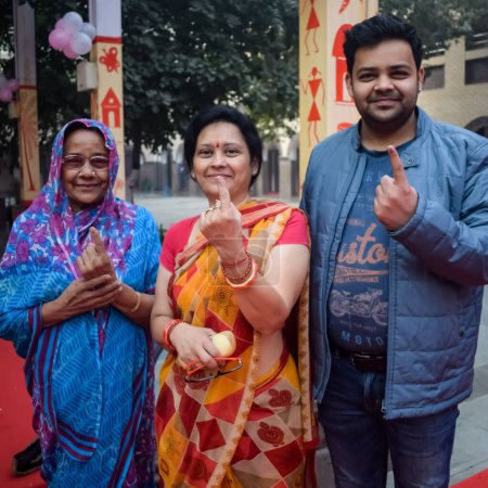 Foto de New Delhi, India - December 04 2022 - Unidentified people showing their ink-marked fingers after casting votes in front of polling booth of east Delhi area for MCD local body Elections 2022 - Imagen libre de derechos