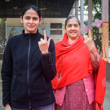 Photo for New Delhi, India - December 04 2022 - Unidentified people showing their ink-marked fingers after casting votes in front of polling booth of east Delhi area for MCD local body Elections 2022 - Royalty Free Image