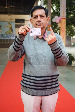 Téléchargez les photos : New Delhi, India - December 04 2022 - Unidentified people showing their ink-marked fingers after casting votes in front of polling booth of east Delhi area for MCD local body Elections 2022 - en image libre de droit