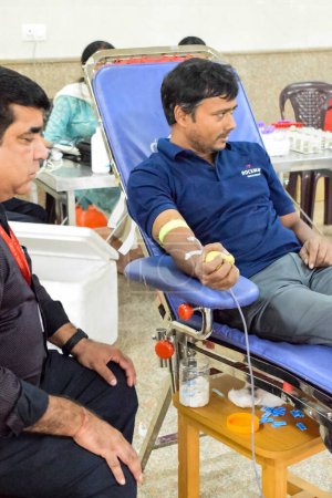 Foto de Delhi, India, 19 de junio de 2023 - Donante de sangre en el campamento de donación de sangre celebrado en el Templo Balaji, Vivek Vihar, Delhi, India, Imagen para el Día Mundial del Donante de Sangre el 14 de junio de cada año, Campamento de Donación de Sangre en el Templo - Imagen libre de derechos
